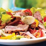 Steak de porc en salade fraîche au bacon